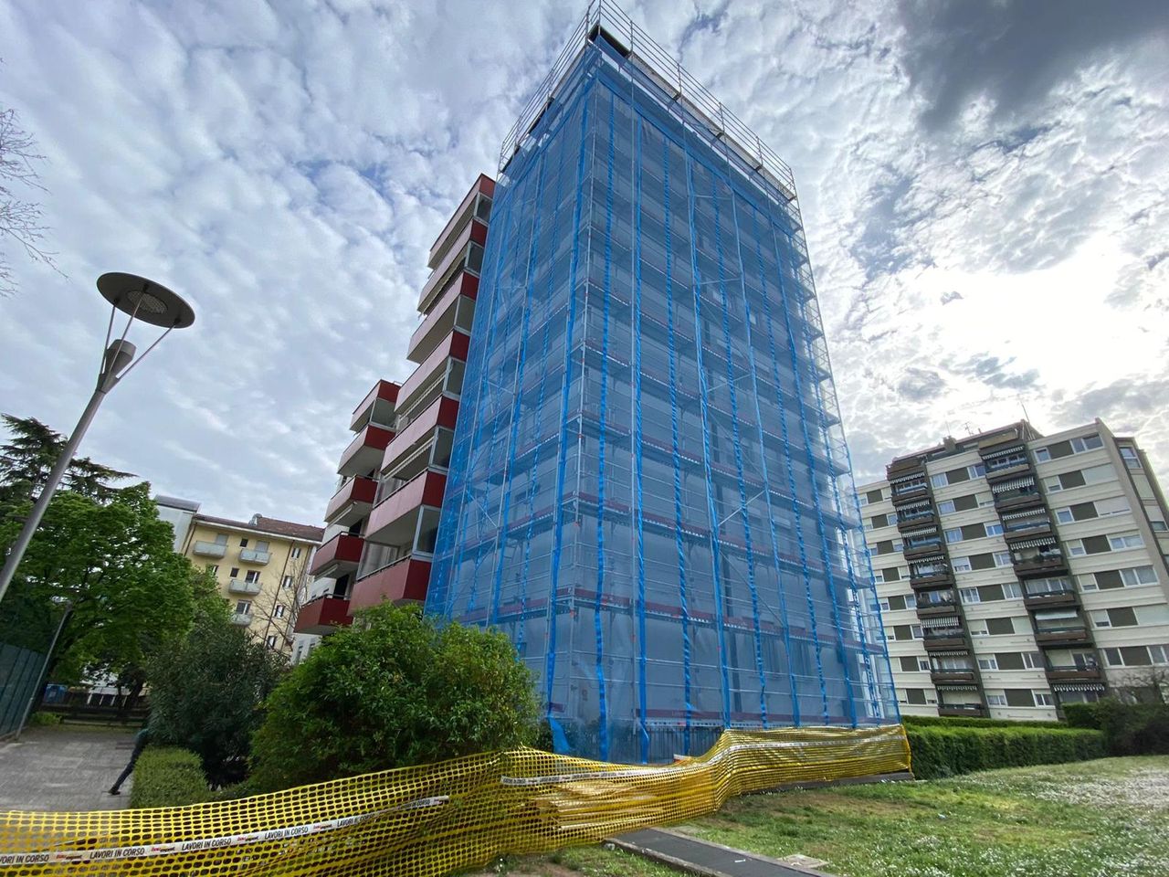 Residential façade covered by scaffolding with blue sheeting